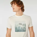Remera blanca de algodón con estampado cuadrado de un bosque con niebla y la frase "DIVE INTO THE REALM OF THE UNSEEN".