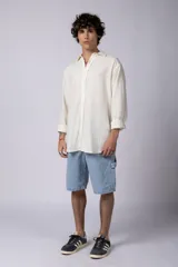 Camisa color arena de lino, manga larga, con cuello clásico y corte holgado.