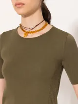 Top negro tejido en hilado frío con calce al cuerpo, mangas cortas y abertura en la espalda que se ata en el cuello.