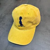 Gorra de jean color mostaza con logo de la marca en azul marino y tamaño ajustable.