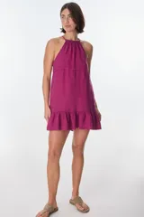 Vestido corto color beige, con escote halter, tirantes finos y falda con volados.