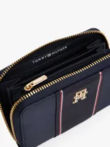 Billetera Tommy Hilfiger azul marino con cierre de cremallera, detalle de tejido trenzado, múltiples ranuras interiores para tarjetas, compartimento interior con cremallera e insignia del monograma TH dorada en la parte delantera.
