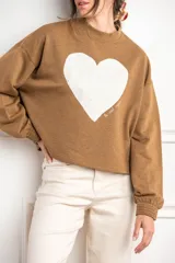 Sweater oversize color camel con estampado de corazón y diseño de mangas largas.
