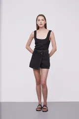 Short de jean negro con corte asimétrico y cierre con botón.