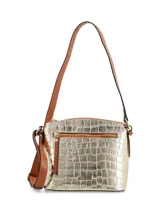 Cartera bandolera dorada con textura croco, correa de cuero marrón regulable y chapita metálica con logo de la marca.