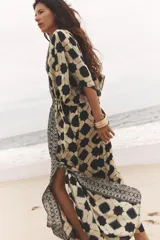 Vestido amplio estilo caftán con estampado geométrico en tonos beige y azul, escote en pico con lentejuelas y manga ancha por debajo del codo. Cintura ajustable con cordones con borlas.