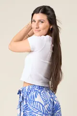 Remera corta color beige de corte ajustado y mangas cortas.