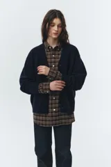 Cardigan de punto azul marino, con cuello en V, botones frontales y puños y ruedo acanalados.