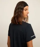 Remera deportiva blanca texturizada, con cuello redondo, manga corta, detalle reflectante y pliegue en la espalda.