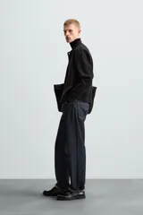Cárdigan negro de punto con cuello solapa, manga larga y cierre frontal con botones.