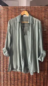 Conjunto de dos piezas: una camisa de seda verde militar, de manga larga y corte holgado, y una musculosa básica a tono.