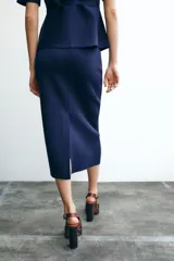 Falda midi azul marino de punto liso, de tiro alto con cintura elástica y abertura en la parte trasera.