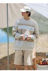 Sweater tejido de punto con rayas horizontales en tonos beige y blanco. Tiene cuello redondo y corte holgado.