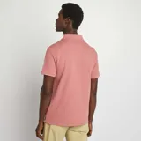 Remera rosa de piqué con cuello polo en V y mangas cortas.