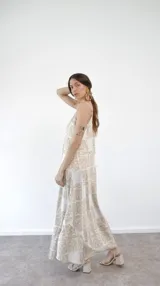 Vestido largo de tirantes finos con estampado de hojas en tonos beige y blanco.