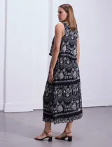 Vestido largo sin mangas de gasa estampada en tonos azules y marrones. Presenta escote redondo y corte en la cintura con punto smock.