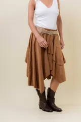 Pollera corta asimétrica de gamuza color marrón, con volados superpuestos y cintura elastizada. Incluye short interno.