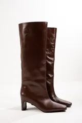 Bota alta de cuero color marrón, con punta cuadrada y taco bloque.