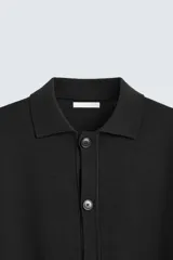 Cárdigan negro de punto con cuello solapa, manga larga y cierre frontal con botones.