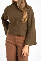 Sweater de punto acanalado color marrón, con cuello alto tipo polera y mangas largas de corte ancho. Posee un diseño oversize confeccionado en mezcla de lana.