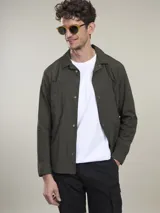 Camisa verde militar de manga larga con cierre de botones, cuello clásico y dos bolsillos frontales con solapa.