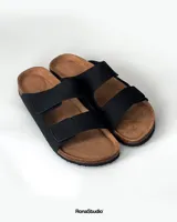 Sandalias negras con dos correas ajustables con velcro, plantilla anatómica de corcho y base antideslizante.