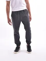 Pantalón jogger gris oscuro con cintura elástica ajustable con cordón y puños elásticos en los tobillos.