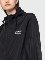 Chaqueta impermeable con capucha Golden Goose modelo Daris, color negro con logo estampado en blanco en el pecho. Cierre frontal con cremallera y cordones ajustables en la capucha.