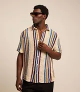 Camisa de manga corta con cuello alto y abotonada, confeccionada en ganchillo rústico con textura.