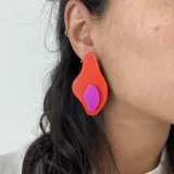 Aros de diseño abstracto en colores rojo y purpura, con formas orgánicas.