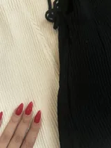 Vestido midi negro de tejido acanalado, al cuerpo con espalda entrelazada que se ajusta al talle.
