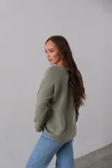 Sweater verde oliva de corte recto y cuello redondo.