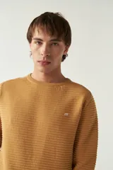 Sweater mostaza de punto con cuello redondo, mangas largas y logo bordado en el pecho. Corte slim fit.