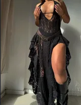 Vestido largo blanco de encaje, con escote halter profundo y volados asimétricos en la falda.