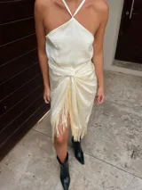 Top color crema de seda, con escote halter y espalda descubierta. Se ata con tiras finas en la nuca y en la espalda.