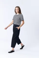 Pantalón negro de corte ancho, con pinzas en la cintura y bolsillos laterales.
