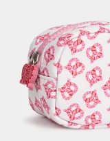Monedero pequeño de tela deportiva color rosa con estampado de manzanas rojas. Tiene cierre circundante con tirador decorativo.