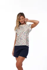 Blusa estampada con flores en tonos rosa, azul y verde sobre fondo blanco. Tiene cuello redondo y mangas cortas con volados.