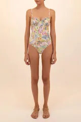Traje de baño entero con estampado floral multicolor, de cobertura media, con copas preformadas, pliegues y varillas. Breteles delgados ajustables y espalda baja con amarre de coletas en la espalda.