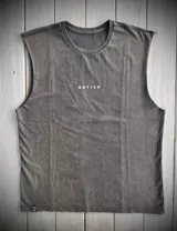 Musculosa verde oliva de algodón con cuello redondo y sisas amplias. Estampado frontal con tres hojas blancas. Diseño unisex y corte holgado.