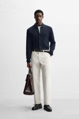 Pantalón chino negro slim fit confeccionado en tejido técnico de secado rápido. Cuenta con bolsillos frontales y traseros de vivo. Cierre frontal con cremallera y botón.