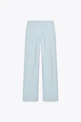 Pantalón celeste de tiro alto con bolsillos delanteros y pernera recta. Cierre frontal con cremallera y botón.