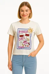 Remera celeste de manga corta y cuello redondo, con estampado de sardinas sobre fondo a cuadros rojos y blancos. Incluye texto con los nombres de las ciudades de Cagliari y Sardina.