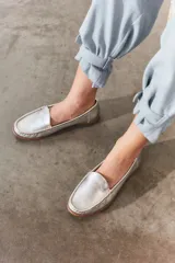 Mocasines de cuero color marrón claro con costuras a la vista.