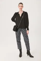 Pantalón babucha negro con estampado floral en tonos celeste y blanco.