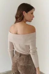 Sweater negro de punto con escote bardot y mangas largas.