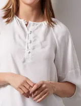 Blusa de gasa blanca, marca Sioni. Cuello a la base y escote en V con botones.