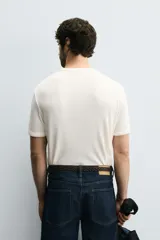 Camiseta de hombre de manga corta, color blanco con rayas horizontales azul marino. Confeccionada en tejido con estructura waffle y corte relaxed fit.
