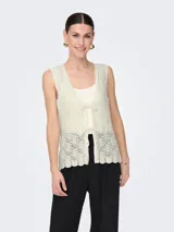 Chaleco de punto color crema con escote en V y lazo delantero. Diseño estructurado y calce ajustado.