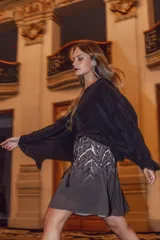 Minifalda plisada de gasa estampada con motivos geométricos en tonos grises y blancos. Tiene cintura elástica con cordón ajustable y largo por encima de la rodilla.